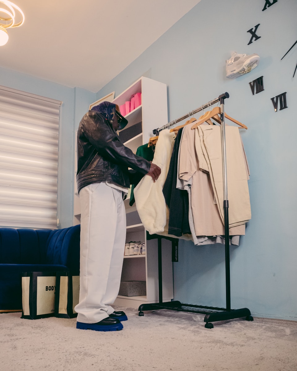a man standing in front of a clothes rack